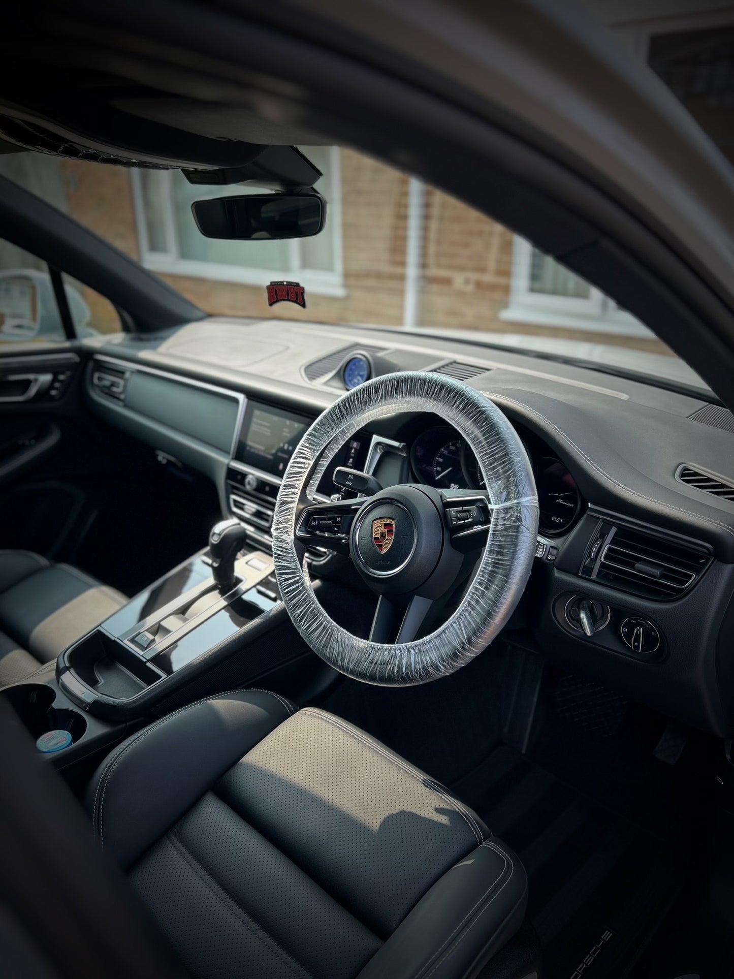 Porsche, interior driver side from the right, steering wheel in leather and console and dashboard on left, leather seat. Car is freshly detailed in northampton