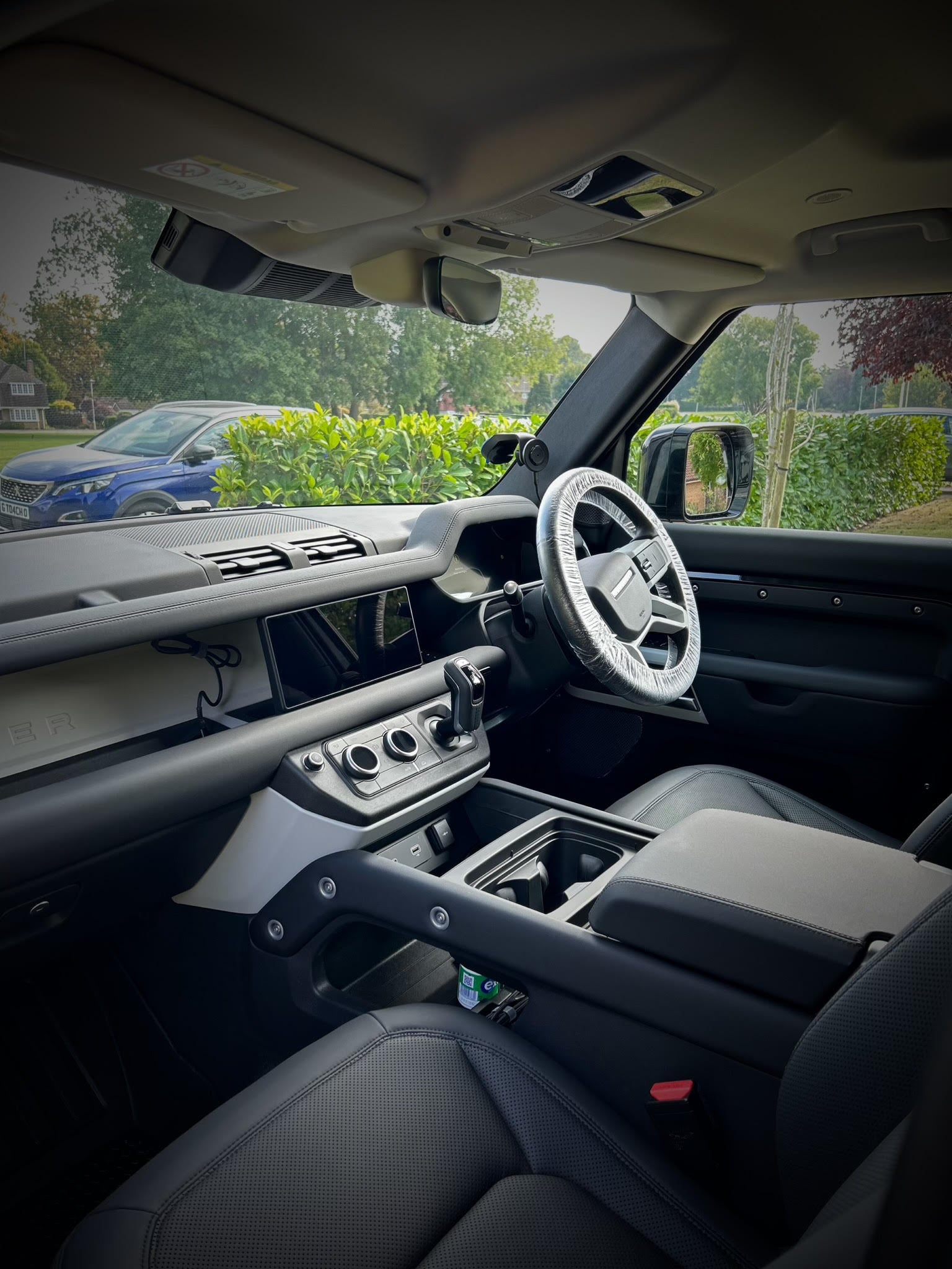 land rover defender 90 interior, from passenger side looking to the drivers side, showing console and steering wheel all clean, interior valet