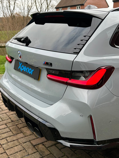 Detailed nardo grey BMW M3 Touring estate with an aggressive rear stance, carbon fiber accents, and LED taillights