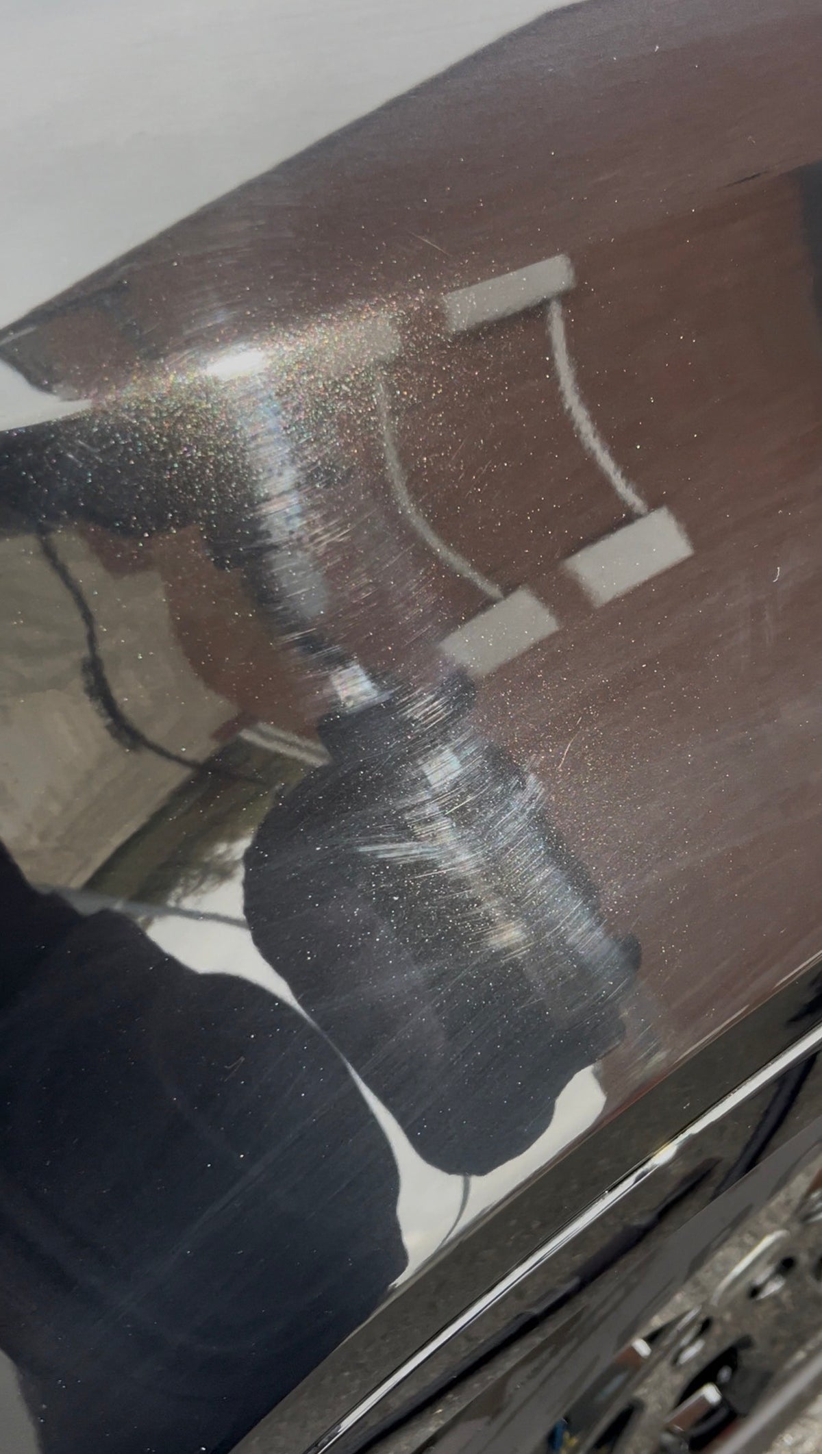 Close-up of black swirled paint before paint correction