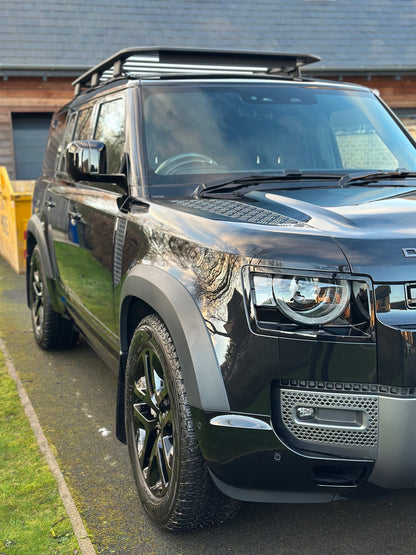 Blacked-out Land Rover Defender 110 with high-gloss black wheels, showcasing premium detailing services